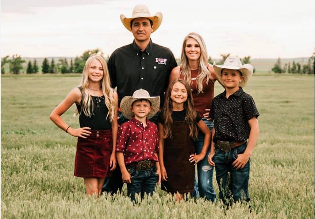 A ranch family standing in a field.