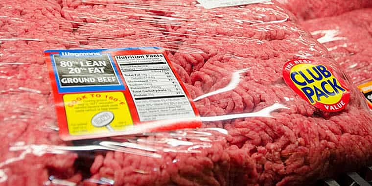 A package of ground hamburger in a grocery store meat case.