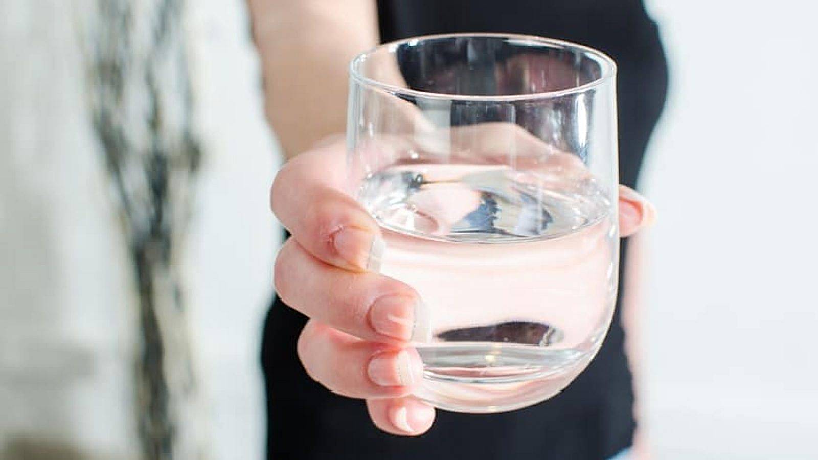 Woman showing a glass of water, closeup