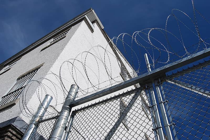 Prison wall with razor wire fence