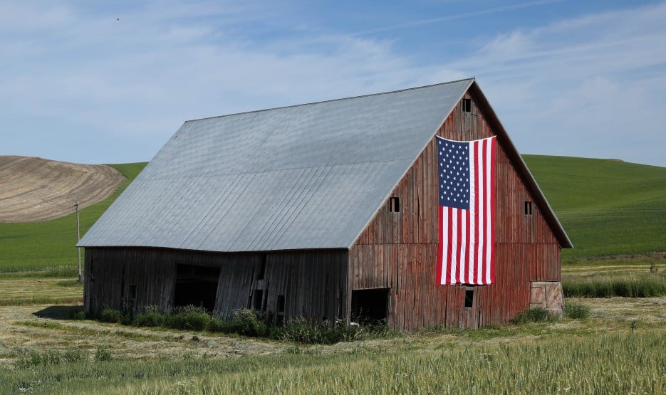 A barn with an American flag on it in rural America.