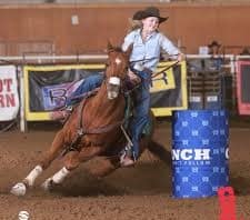 A cowgirl barrel racing at a rodeo