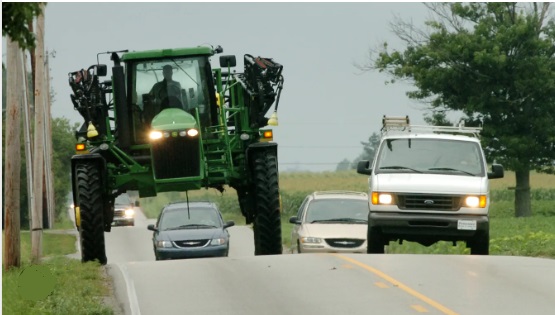 A crop sprayer travels on a highway.