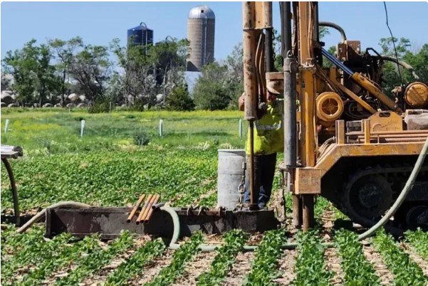 Laying a carbon pipeline in a farm field.